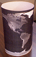 A map of the Earth, showing continents and oceans, taped together to form a cylinder.